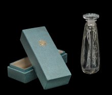 Perfume Bottle with Stopper and Box, Coty - 2, Cyclamen, designed 1909. Mold-blown glass bottle and mold-pressed glass stopper, acid-etched, applied patina. Bottle: H. 14 cm, W. 5 cm, D. 5 cm; Box: H. 15 cm, W. 6.5 cm, D. 6 cm. (96.3.44)