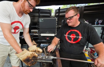 Gaffers George Kennard and Dane Jack work with designer Tom Scott at GlassLab in Corning